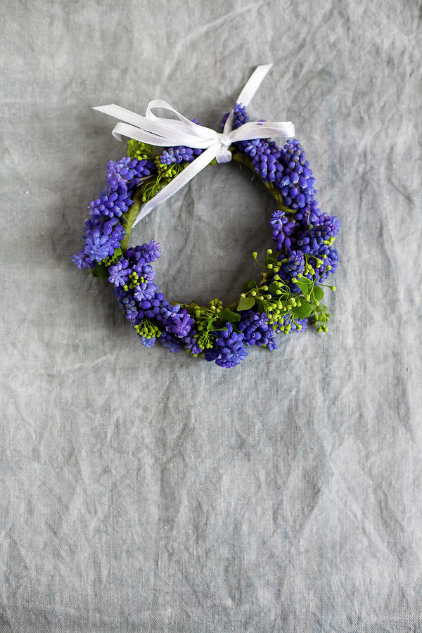 Small Wreath Of Grape Hyacinth Flowers With White Ribbon On Grey Surface Photograph by Alicja Koll