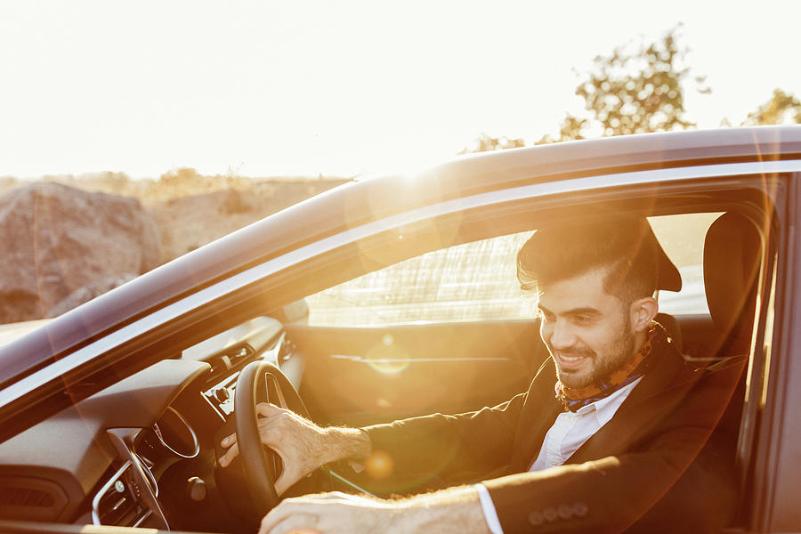 Smiling Hot Man In Suit Driving A Car During Golden Hour Photograph by ...