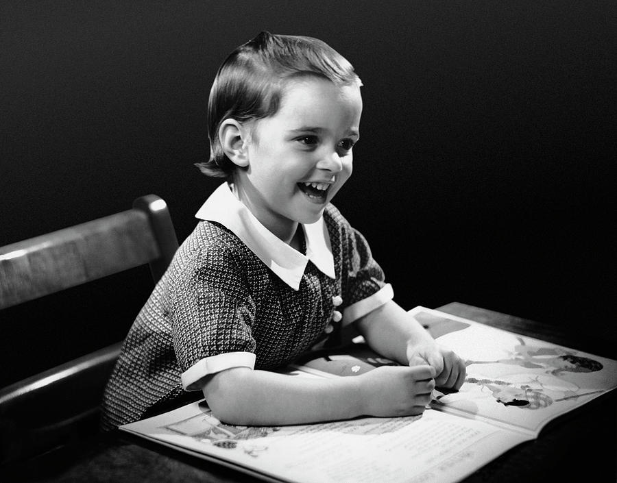 Smiling Young Girl Reading Book Photograph by George Marks