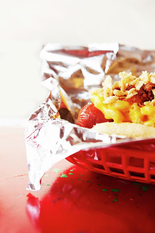 Cheese Photograph - Smoked Chili Dog Topped With Cheesy Macaroni And Cheese; In A Plastic Basket by Rannells, Greg