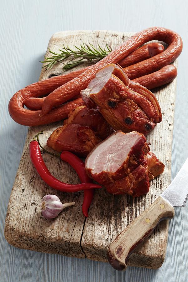 Smoked Meat And Sausages On A Wooden Cutting Board Photograph by Zemgalietis, Maris
