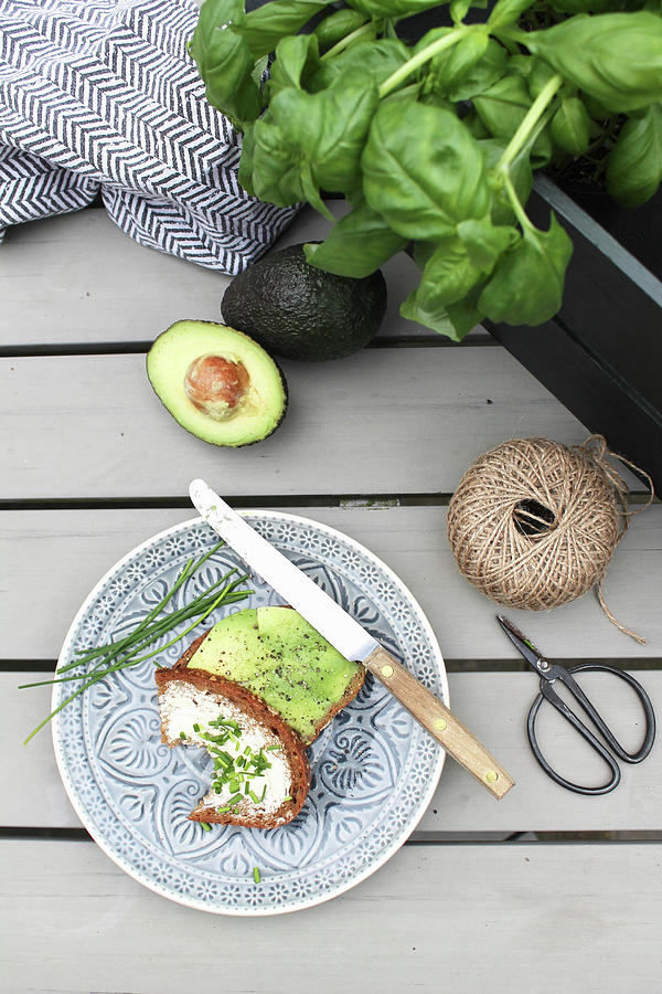 Snack Of Bread, Avocado And Chives In Garden Photograph by Britta Bloggt
