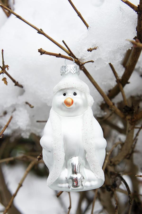 Snowman Bauble Hung From Snow-covered Branch In Garden Photograph by Martina Schindler