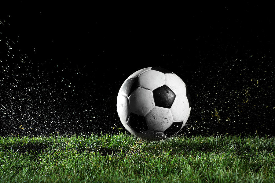 Soccer Ball In Motion Over Grass Photograph by Thomas Northcut