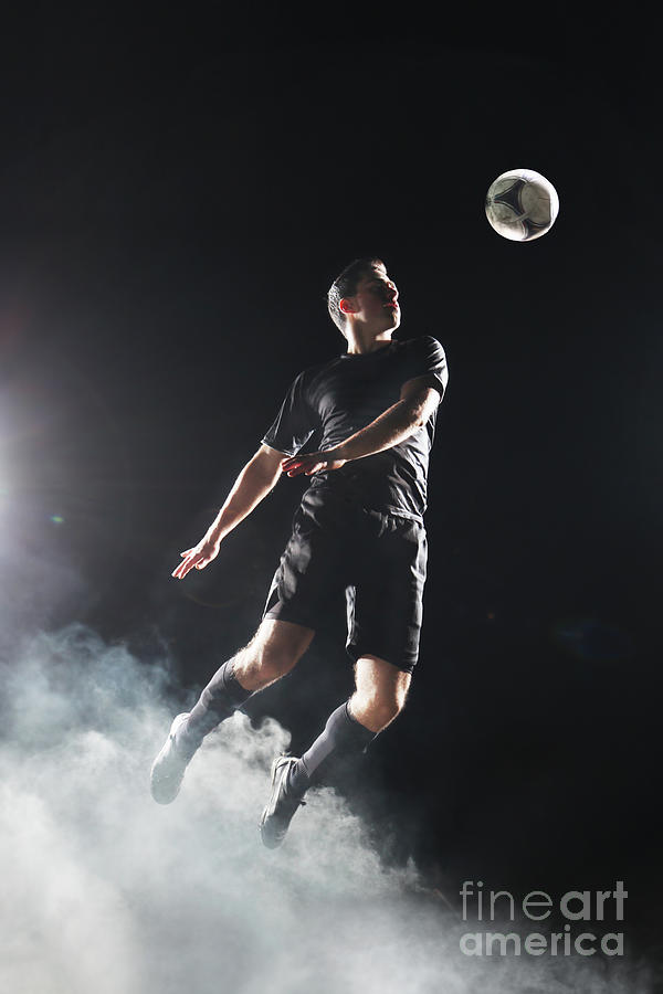Soccer Player Jumping To Ball Photograph by Stanislaw Pytel