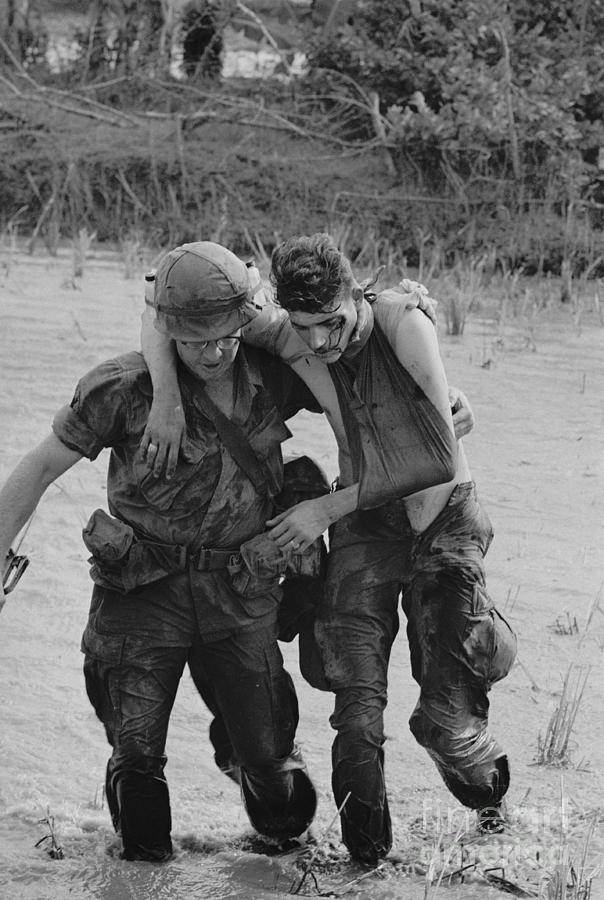 Vietnam War Photograph - Soldier Helping Wounded Soldier by Bettmann