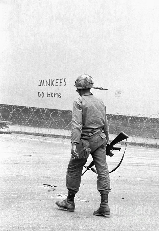 Soldier Walks Past Graffiti Photograph by Bettmann