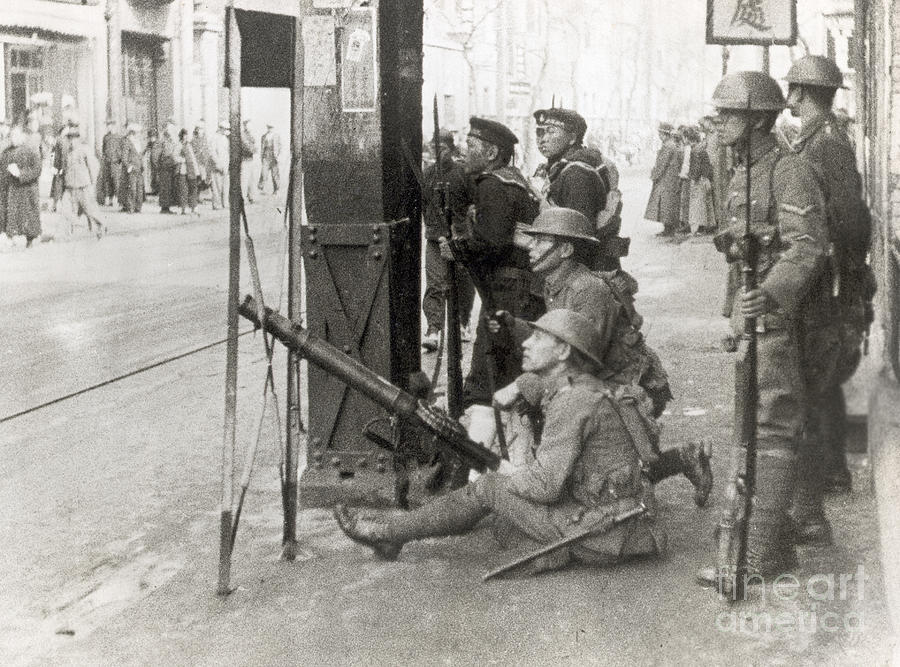 Soldiers Aiming Gun On City Street by Bettmann