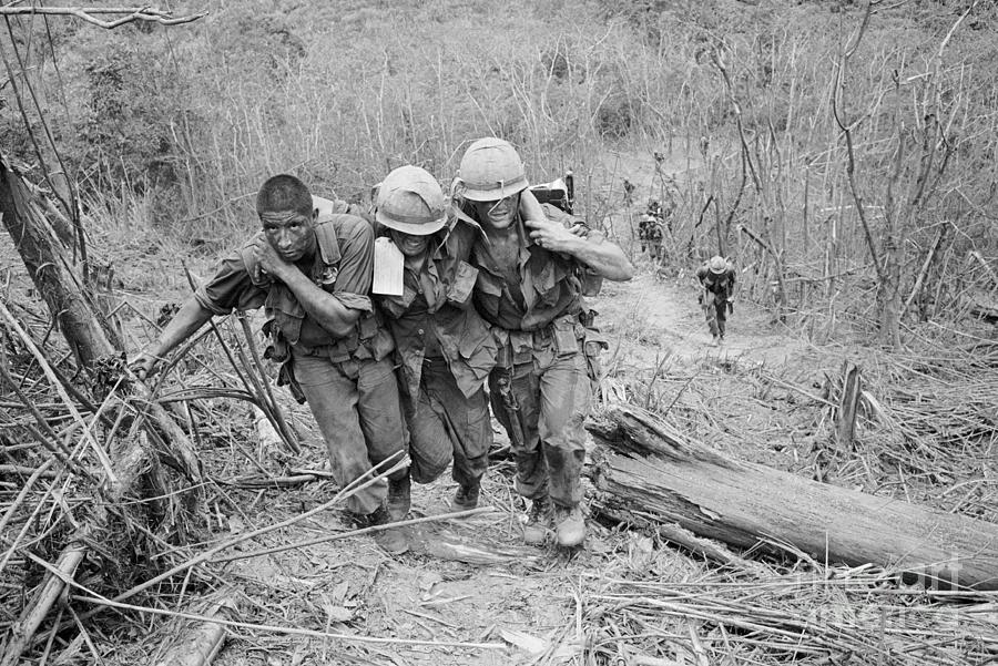 Soldiers Helping Wounded Marine Photograph by Bettmann