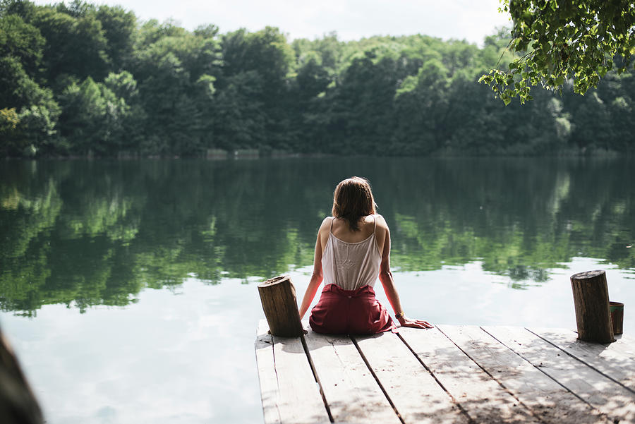 Solitary Person Sitting On Wooden Jetty Looking At Lake In Summer ...