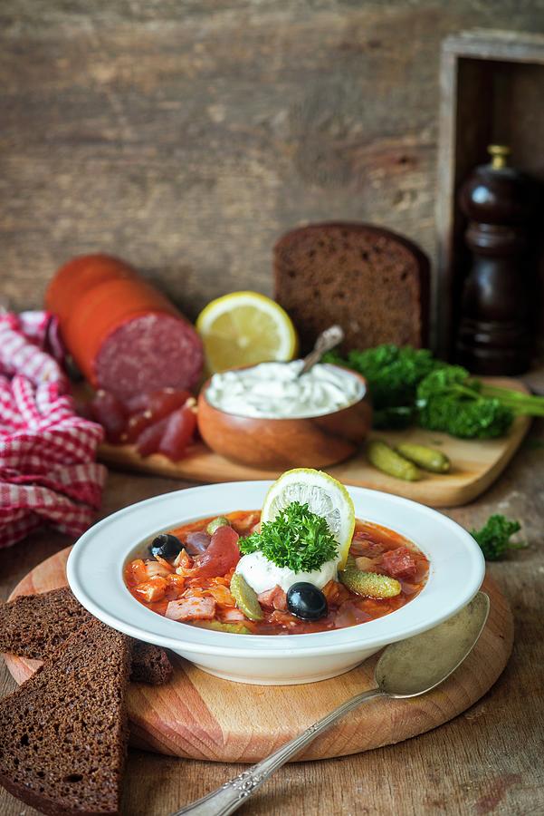 Solyanka traditional Russian Meat Soup From Different Kinds Of Meat And Sausages With Pickled Cucumber And Lemon Photograph by Irina Meliukh