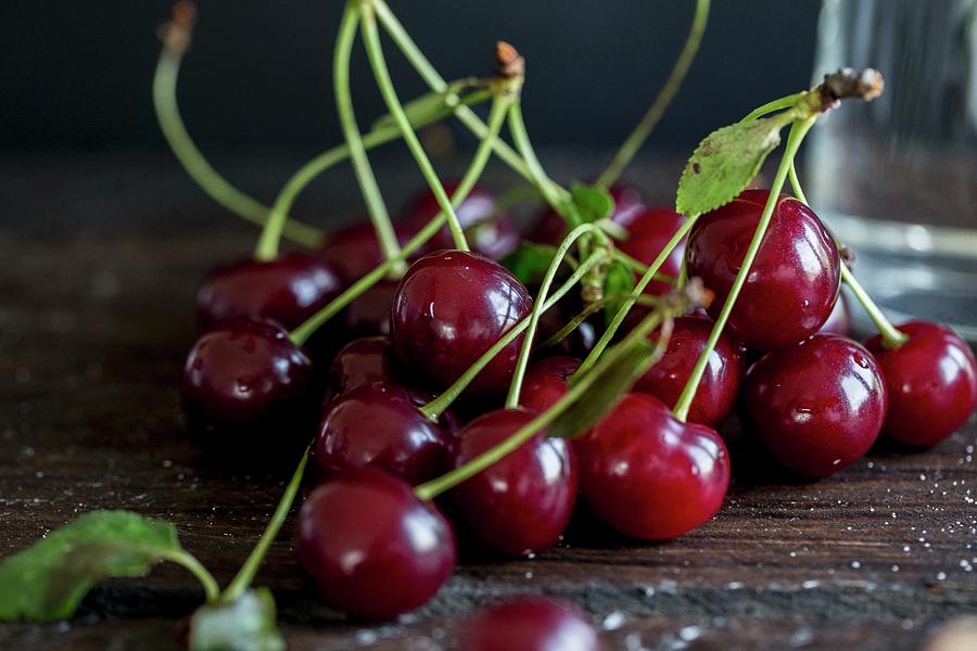Sour Cherries On A Dark Surface Photograph by Nicole Godt