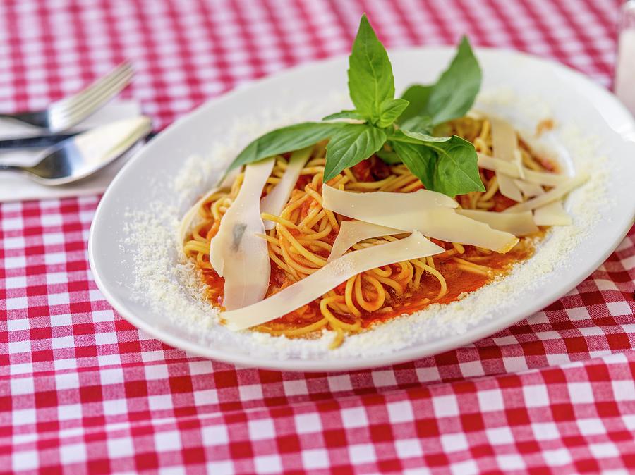 Spaghetti With Tomato Sauce And Parmesan Cheese On A Checked Tablecloth Photograph by Manuel Krug