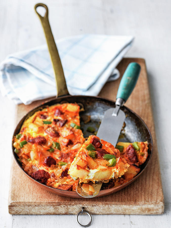 Spanish Tortilla In Fry Pan With Chorizo Green Peppers Potatoes Onions Pumpkin And Eggs Showing Slices Out On Pallette Knife Photograph by Michael Paul