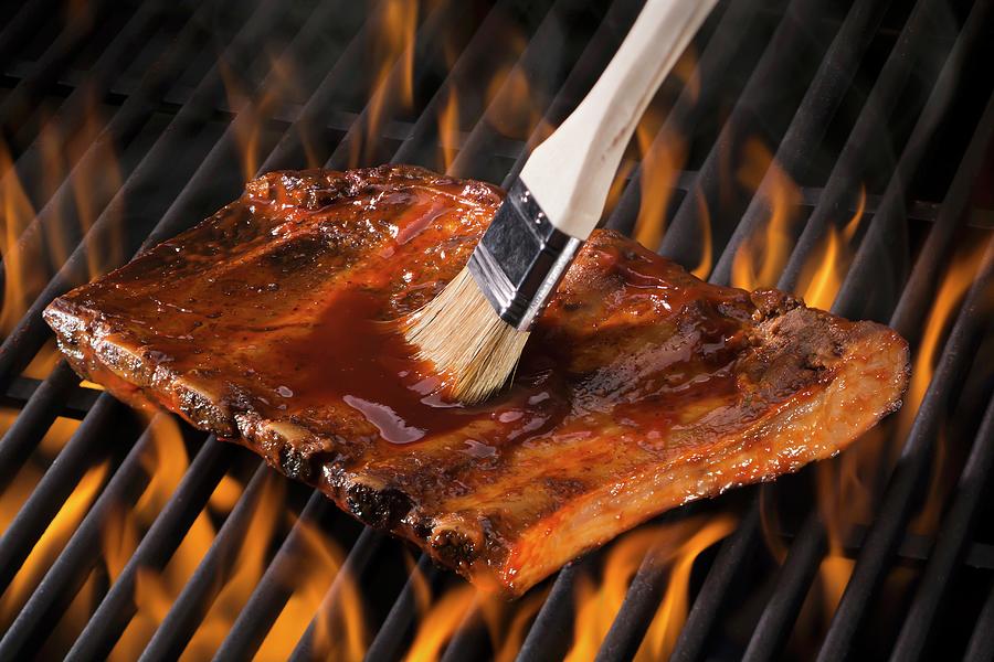 Spare Ribs Being Brushed With Marinade On A Hot Grill Photograph by Brian Enright