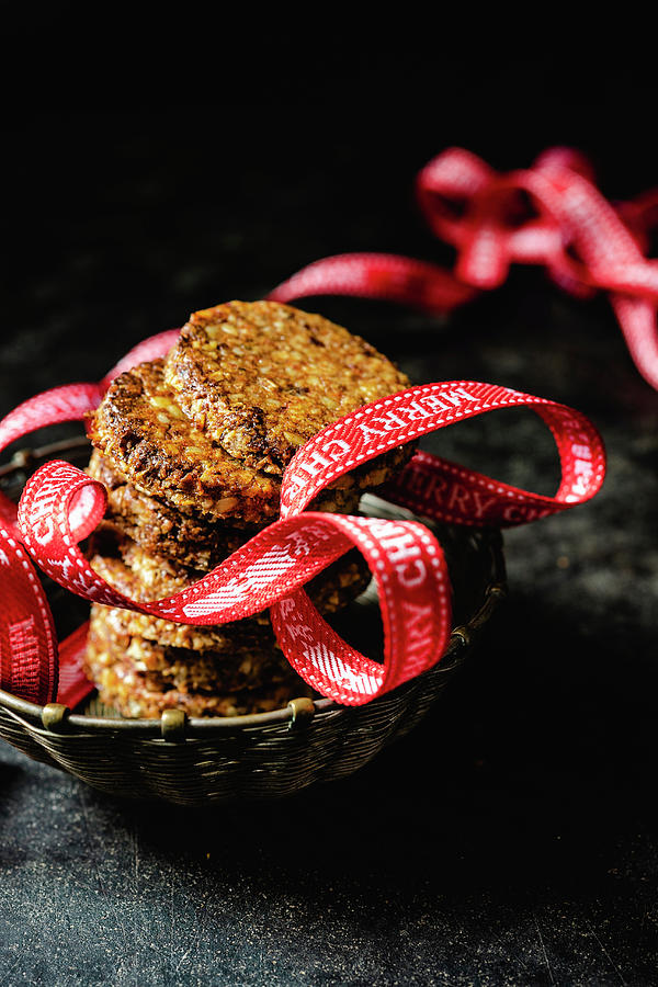 Spiced Biscuits With Walnuts, Dates, Coconut Flakes And A Christmas Ribbon Photograph by Elisabeth Von Plnitz-eisfeld