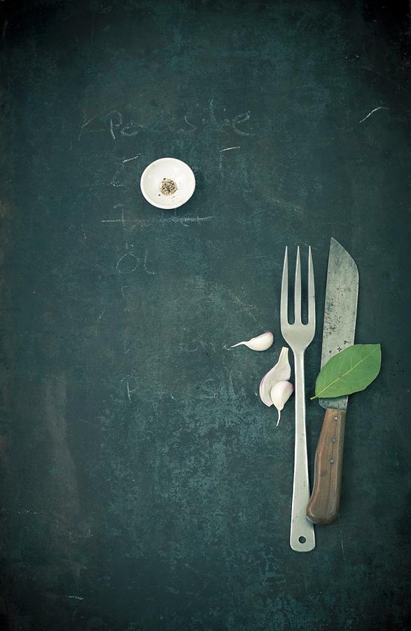 Spices, A Garlic Clove And A Bay Leaf With A Knife And Fork Photograph by Jalag / Wolfgang Schardt