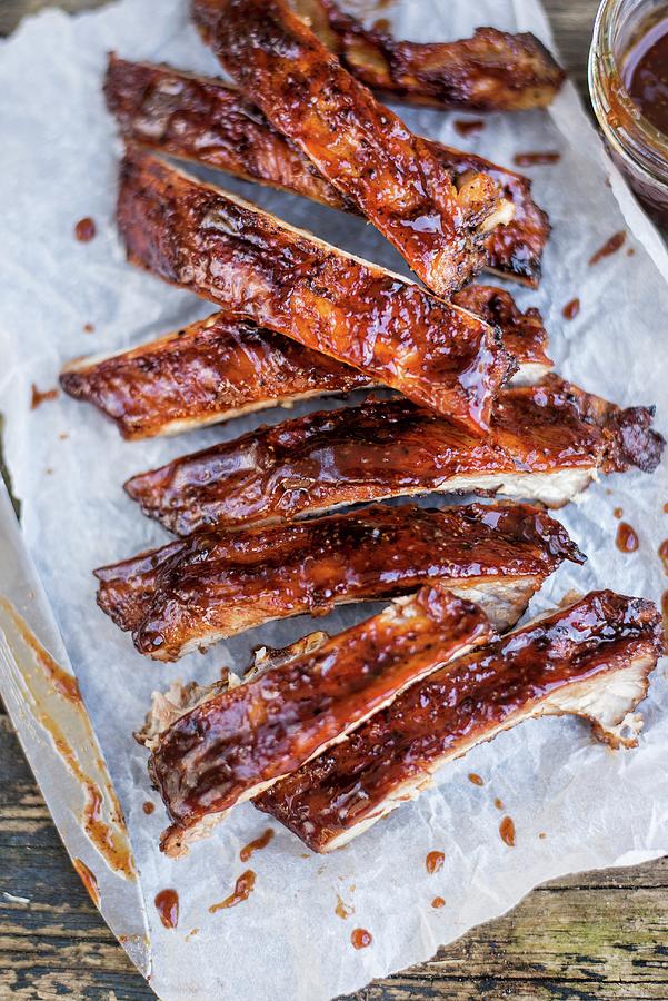 Spicy Pork Ribs With Bourbon Barbecue Sauce On Paper close-up Photograph by Lucy Parissi