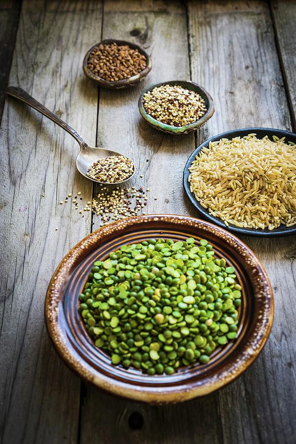 Split Peas, Brown Rice, Quinoa And Buckwheat On A Wooden Surface Photograph by Alena Haurylik