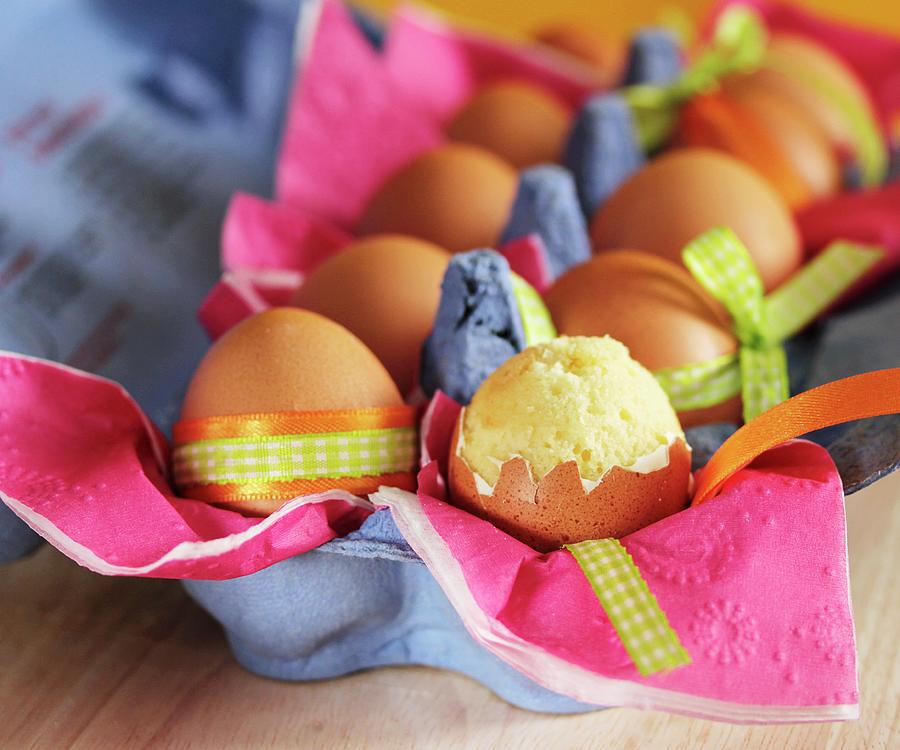 Sponge Cake In An Eggshell In A Full Carton Of Eggs With Easter Decorations Photograph by Vivi Dangelo
