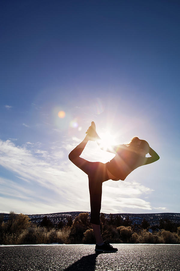 Nature Photograph - Sporty Woman Practicing Yoga On Street Against Sky During Sunny Day by Cavan Images