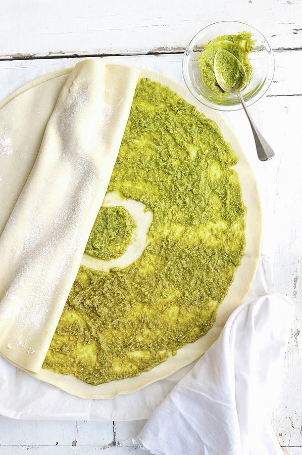 Spreading The Pesto Paste Onto The Round Sheet Of Filo Pastry And Cover With Another One Photograph by Keroudan