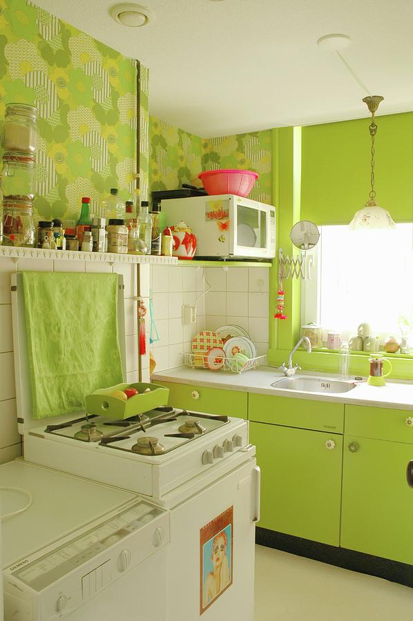 Spring Atmosphere In Fitted Kitchen - Lime Green Cupboard Fronts And 70s-style Floral Wallpaper Photograph by James Stokes