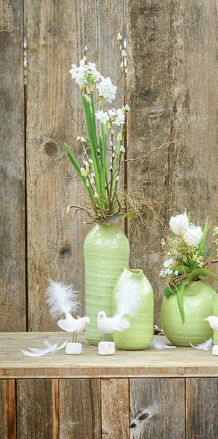 Spring Flowers In Green Vases In Front Of Rustic Wooden Wall Photograph by Patsy&christian