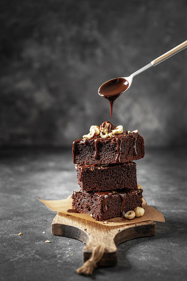 Stack Of Brownie With Nuts And Pouring Chocolate Sauce Photograph by Julie Taras
