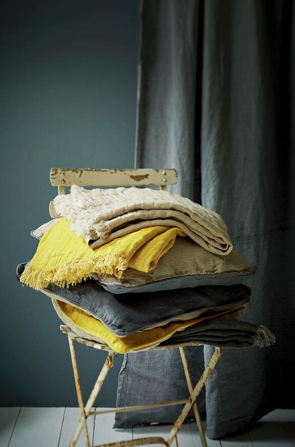 Stack Of Cushions And Cloths In Shades Of Blue And Yellow On Old Garden Chair Photograph by Michael Lffler