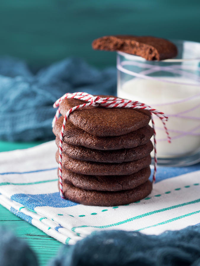 Stack Of Home Made Chocolate Cookies With Red Twine Over Green Background Photograph by Sofya Bolotina