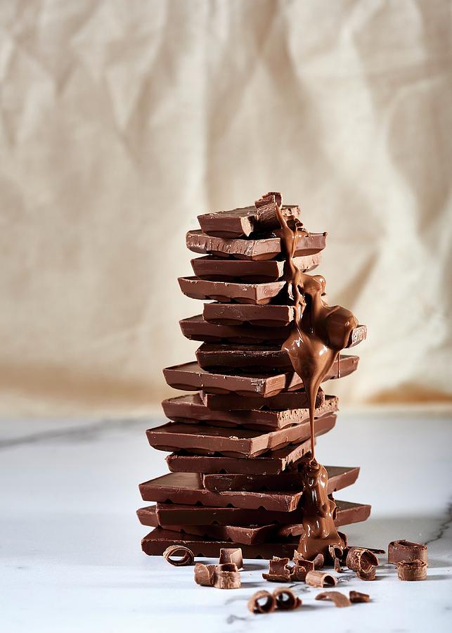 Stacked Blocks Of Chocolate With Chocolate Sauce And Chocolate Curls Photograph by Great Stock!