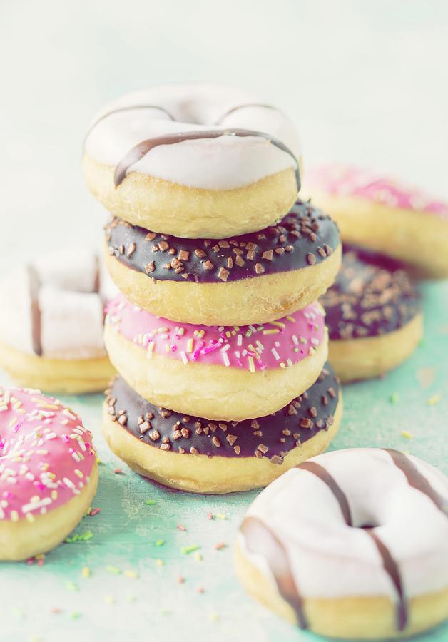 Stacked Doughnuts With Different Glazes And Sugar Sprinkles Photograph by Jan Wischnewski