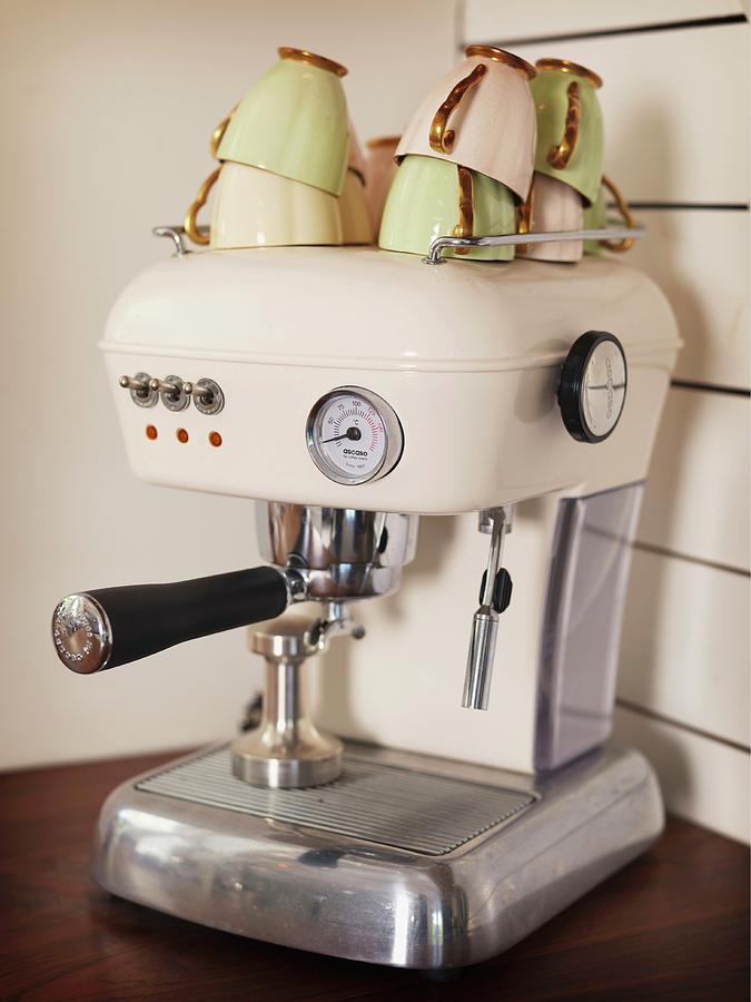 Stacked, Vintage Coffee Cups On Top Of Cream-coloured, Retro Espresso Machine On Kitchen Worksurface Photograph by Peter Carlsson
