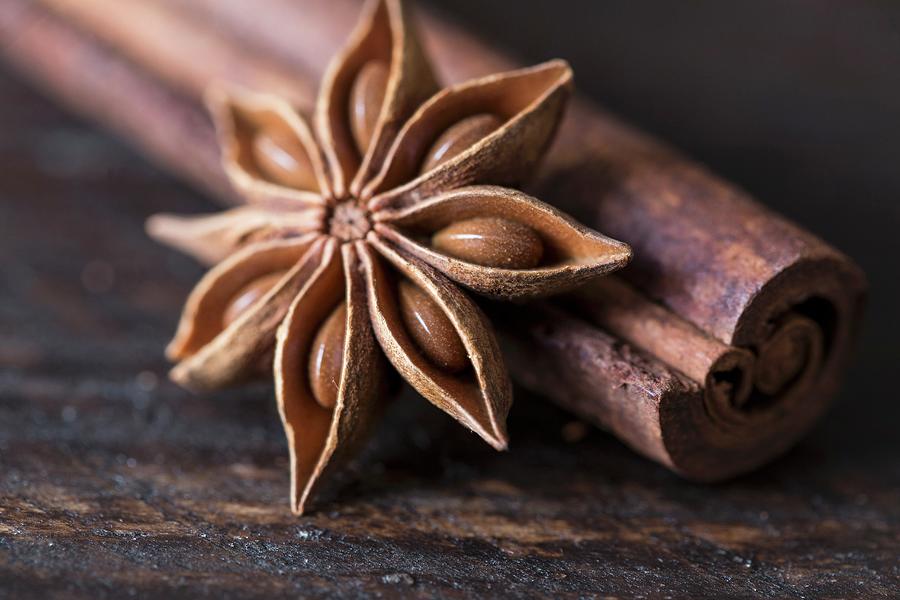 Star Anise And Cinnamon Sticks On A Wooden Surface Photograph by Nicole Godt