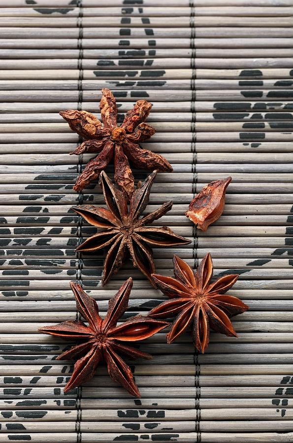 Star Anise On A Bamboo Mat Photograph by Petr Gross