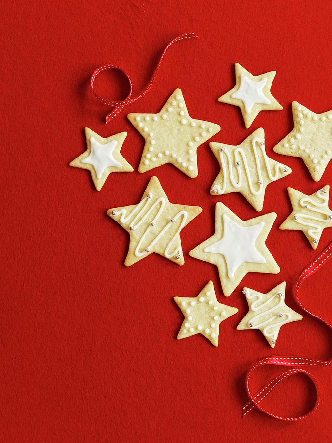 Star Cookies For Christmas In Front Of A Red Background Photograph by Gareth Morgans