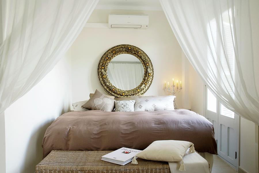 Stately Bed Behind Open Curtains; Large, Round, Gilt-framed Mirror Above Head Photograph by Blickpunkte
