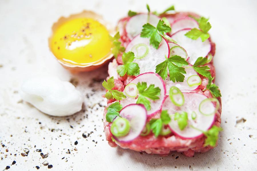 Steak Tartare Topped With Radishes And Parsley Garnish With An Egg And Truffle Foam Next To It Photograph by George Blomfield