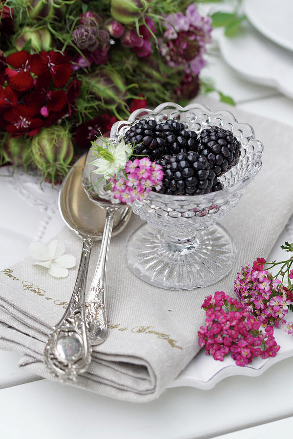 Still Life With Blackberries In Glass Bowls, Next To A Silver Spoon And Flowers Photograph by Angelica Linnhoff