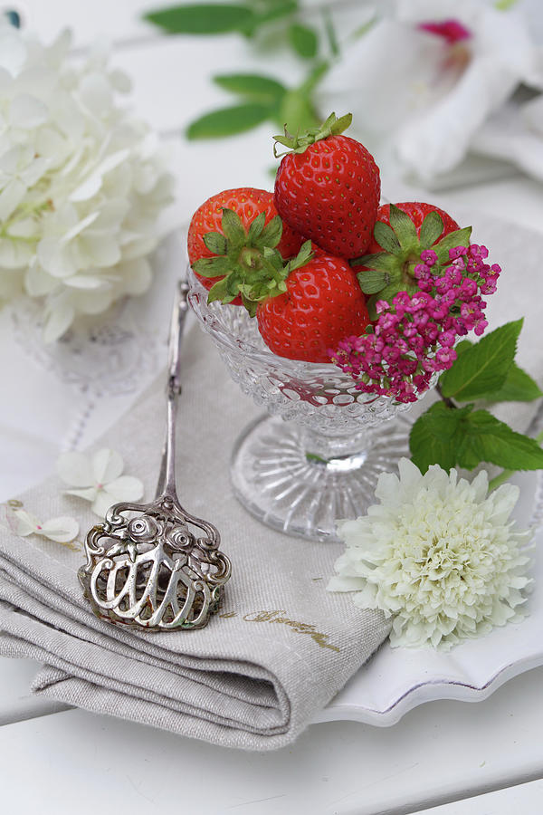 Still Life With Strawberries In Glass Bowls, Flowers And Silver Pastry Tongs Photograph by Angelica Linnhoff