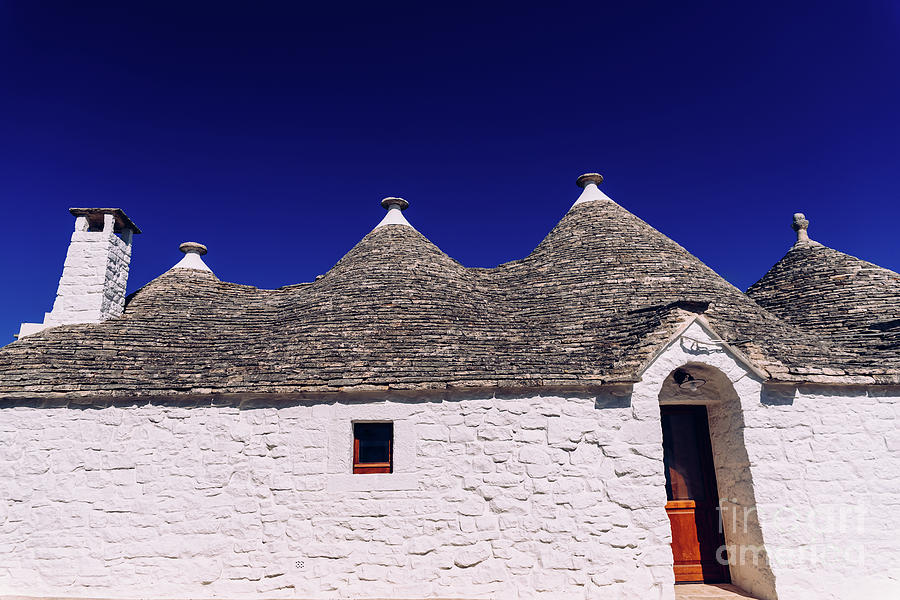 Stone tiles cover the roofs of the trulli in Alberobello, an Italian city to visit on a trip to Italy. Photograph by Joaquin Corbalan