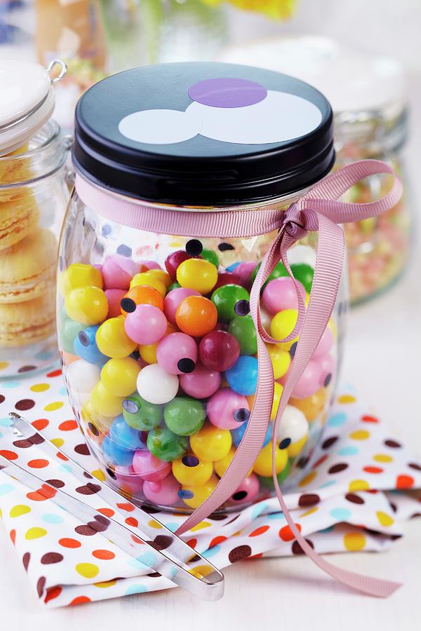Storage Jar Of Colourful Gumballs Decorated With Pink Ribbon Photograph by Franziska Taube