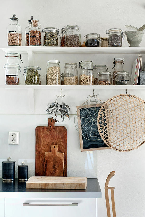 Storage Jars On Two Shelves With Hooks Below In Kitchen Photograph by Magdalena Bjrnsdotter