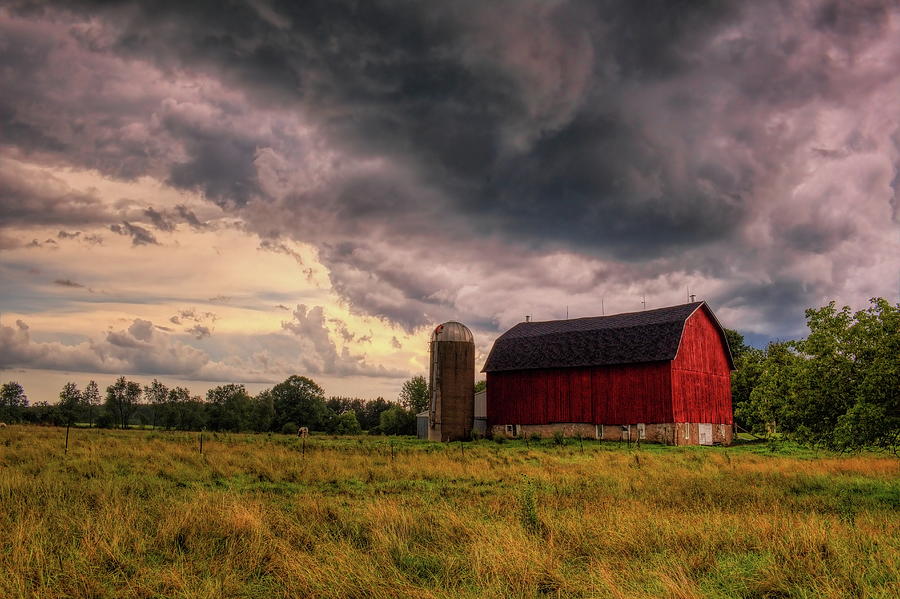 Storming Over A Red Barn Photograph by Dale Kauzlaric