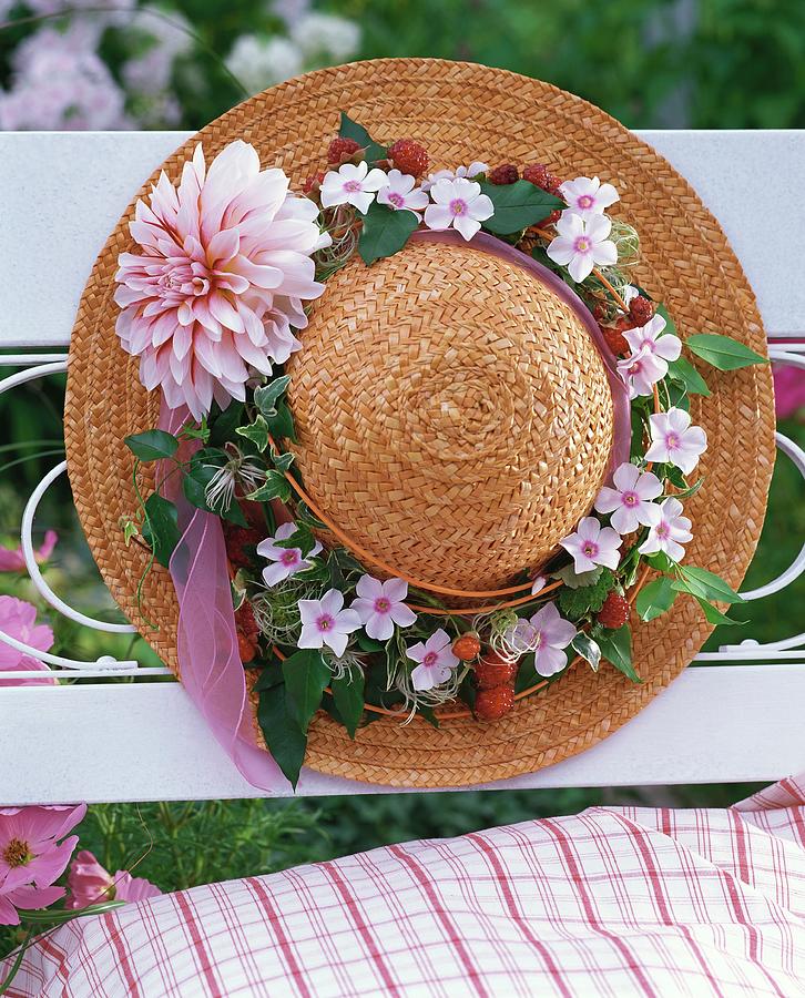 Straw Hat Decorated With Clematis Wreath On Garden Bench Photograph by Friedrich Strauss