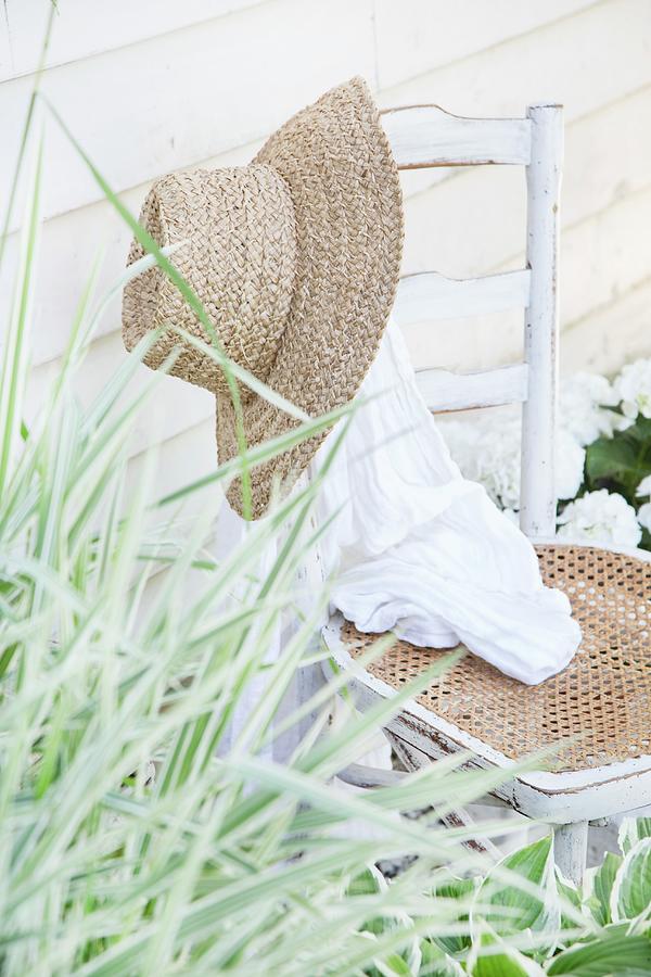 Straw Hat On Backrest Of Old Chair Photograph by Catja Vedder