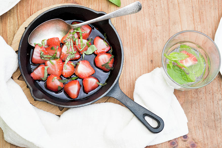 Strawberries Grilled In Sugar With Basil On A Wooden Table With A Glass Of Water With Mint Photograph by Lucie Beck