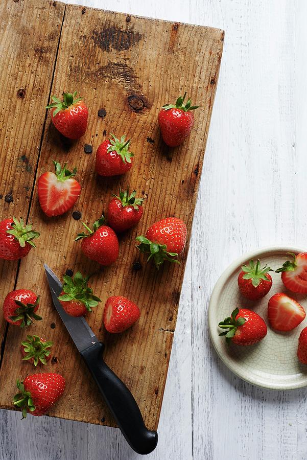 Strawberries On A Rustic Wooden Chopping Board Photograph by Amanda Stockley