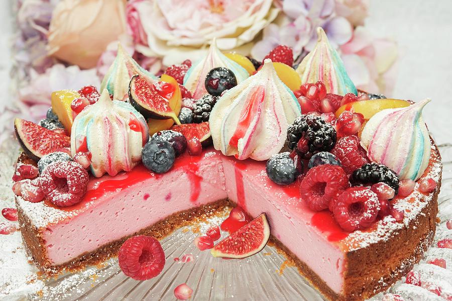 Strawberry Cheesecake With Merangue Kisses And Fresh Fruit On The Top On A Glass Cake Stand In Front Of Flowers Photograph by Linda Burgess